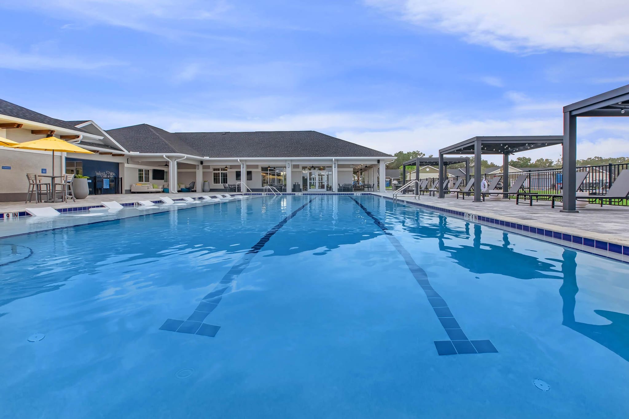 Commercial pool with lap lanes and a shaded amenity deck