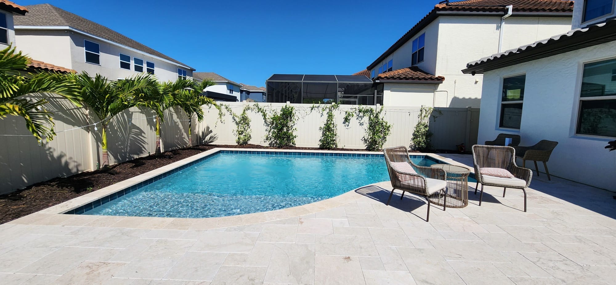 Resort-style pool and spa with travertine deck by Grunit