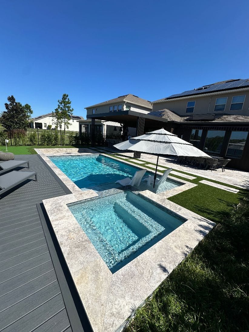 Pool with sun shelf and spa by Grunit